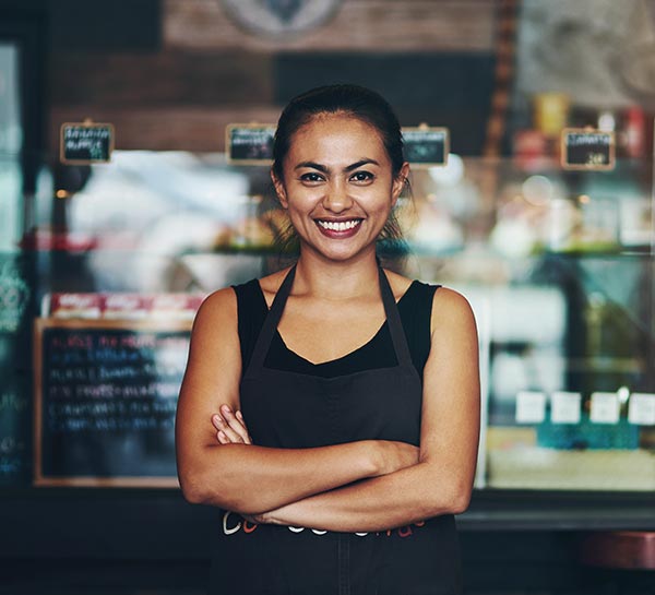 Female Hospitality Industry Ambassador with arms folded smiles at the camera