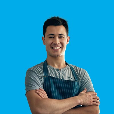 Asian man in apron smiling at camera